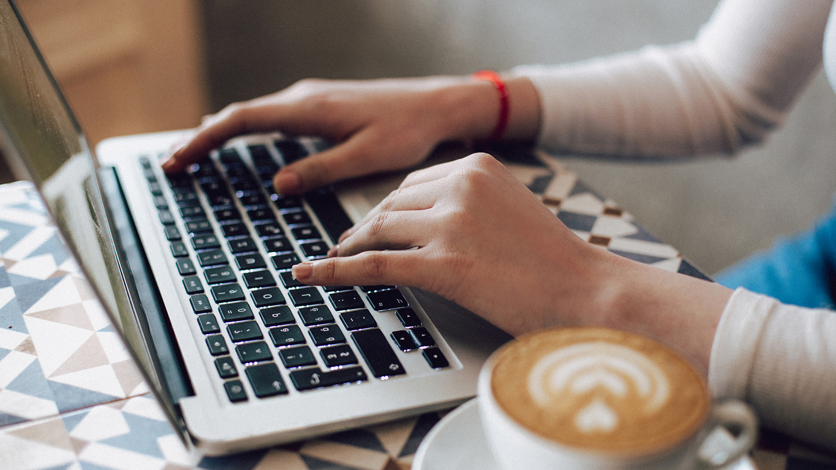 Woman on laptop with a cup of coffee.